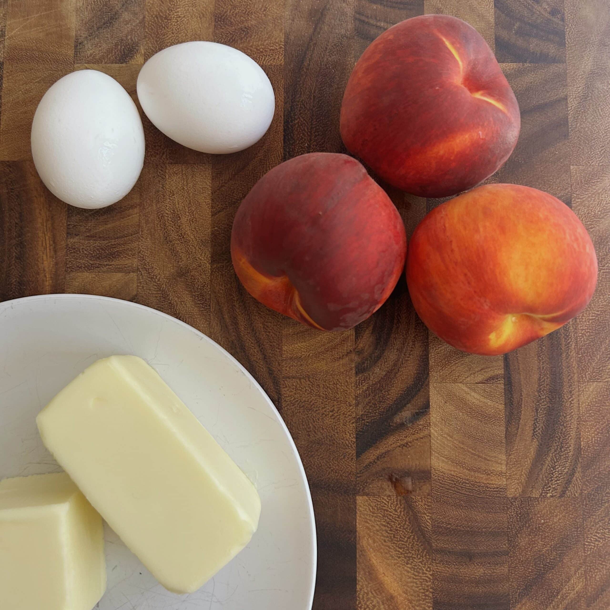 Fresh peaches, butter, and eggs for this peach cake recipe.