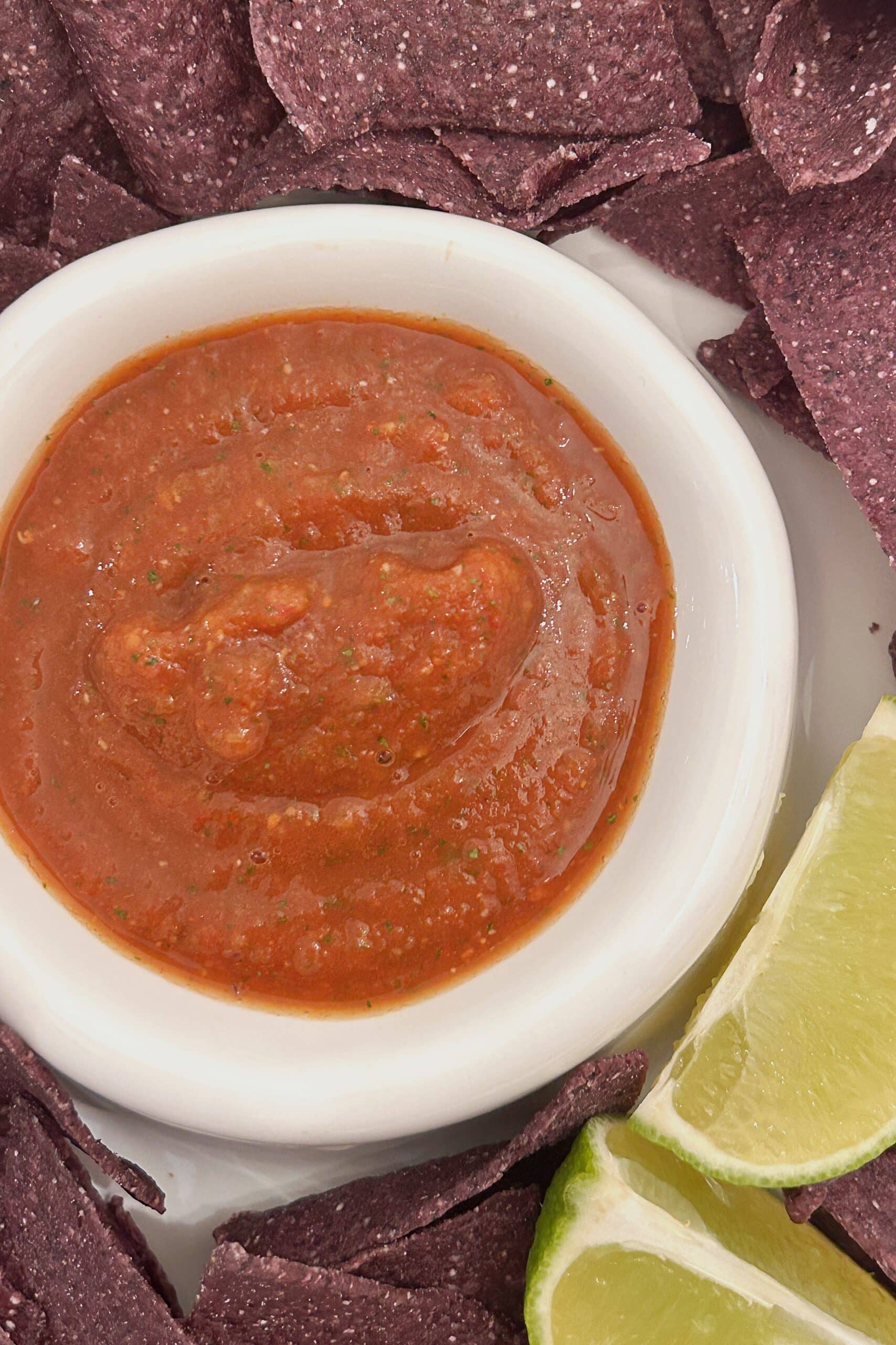 Easy homemade salsa recipe served with blue corn tortilla chips and limes.