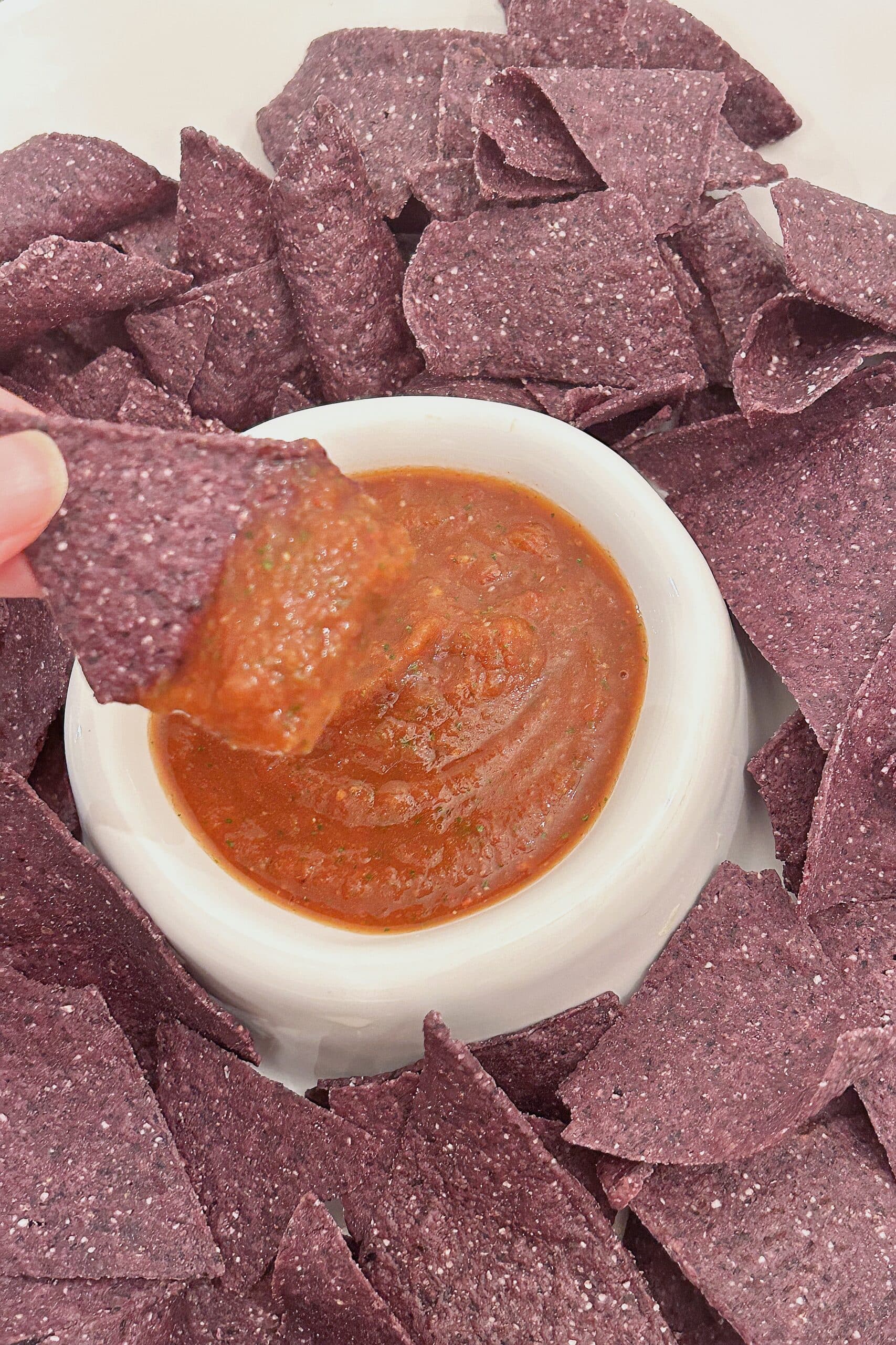 Dipping a chip into homemade salsa.